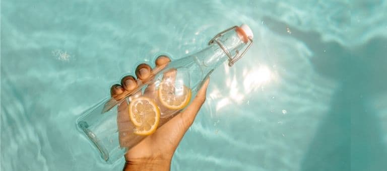 İçinde limon dilimleri olan bir cam su şişesi