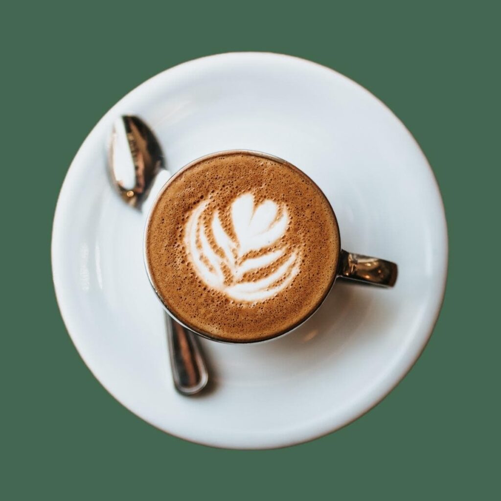 beyaz porselen kahve fincanında köpüklü kahve ve latte kaşığı